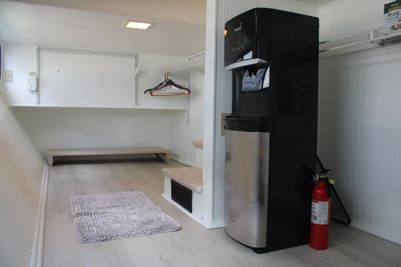 Slide: The Image of Laundry room in a 1992 Sumerset 66 houseboat with water dispenser and fire extinguisher. - 65