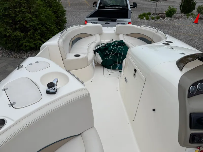 Slide: The Image of 1999 Chaparral Sunesta 232 boat interior with seating and dashboard, parked near a truck. - 10