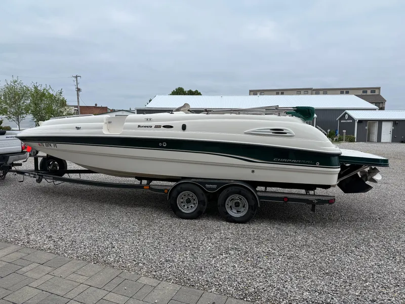 Slide: The Image of 1999 Chaparral Sunesta 232 boat on trailer, parked on gravel, overcast sky. - 4