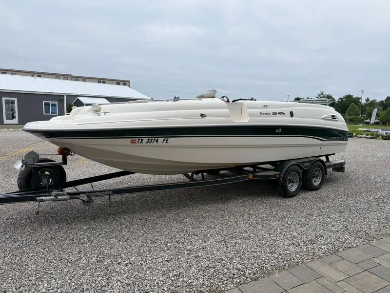 Slide: The Image of 1999 Chaparral Sunesta 232 boat on trailer, parked on gravel near a building. - 5