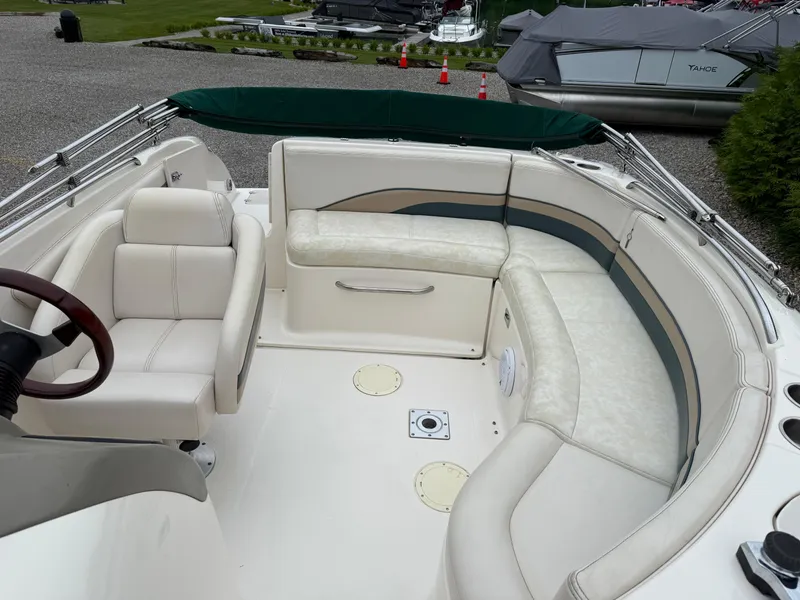 Slide: The Image of 1999 Chaparral Sunesta 232 boat interior with white seating and steering wheel. - 8