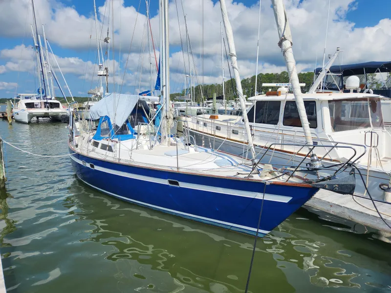 The Image of 1989 Taswell 43 sailboat docked in a marina under a partly cloudy sky. - 1