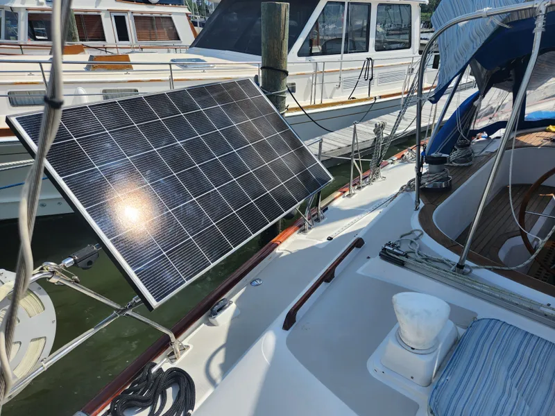 Slide: The Image of 1989 Taswell 43 sailboat with solar panel on deck, docked alongside other boats. - 12