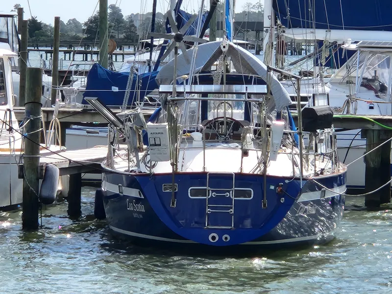Slide: The Image of 1989 Taswell 43 sailboat docked in a marina, surrounded by other boats. - 14