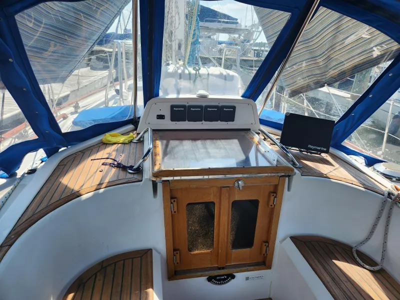 Slide: The Image of Cockpit of 1989 Taswell 43 sailboat with wooden seating and navigation equipment. - 16