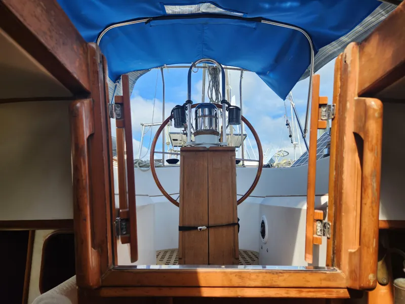 Slide: The Image of Cockpit view of 1989 Taswell 43 sailboat with wooden details and blue canopy. - 18