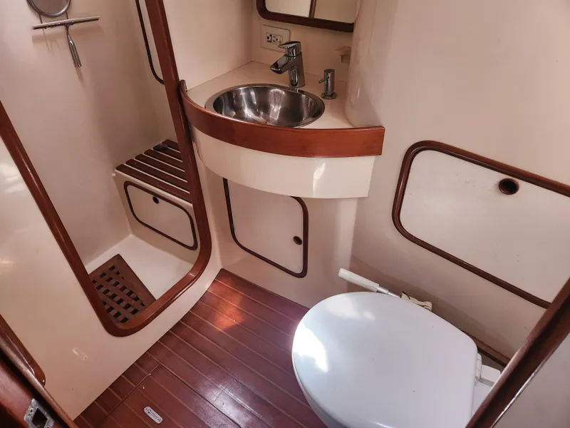 Slide: The Image of 1989 Taswell 43 yacht bathroom with sink, toilet, and wooden accents. - 21