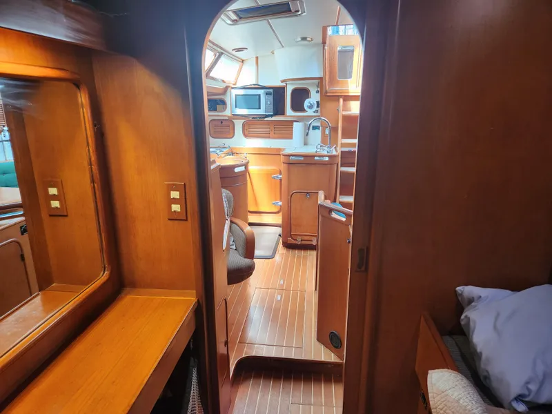 Slide: The Image of Interior of 1989 Taswell 43 sailboat, featuring wooden cabinetry and modern amenities. - 22