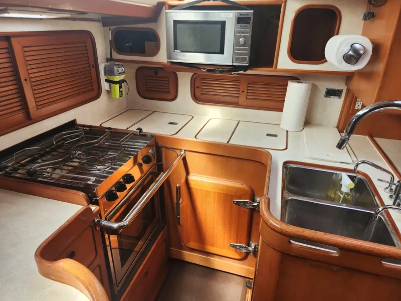 Slide: The Image of 1989 Taswell 43 yacht kitchen with stove, microwave, and sink. - 23