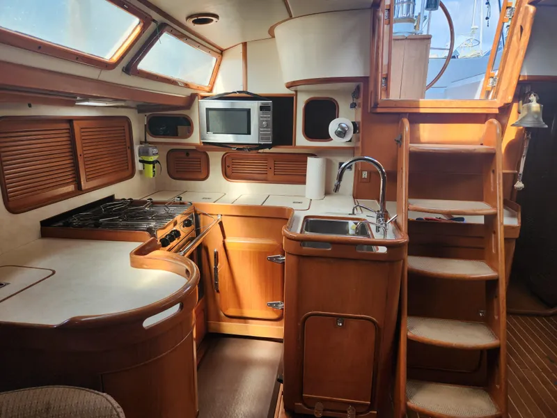 Slide: The Image of Interior of 1989 Taswell 43 sailboat kitchen with wood cabinetry and modern appliances. - 24