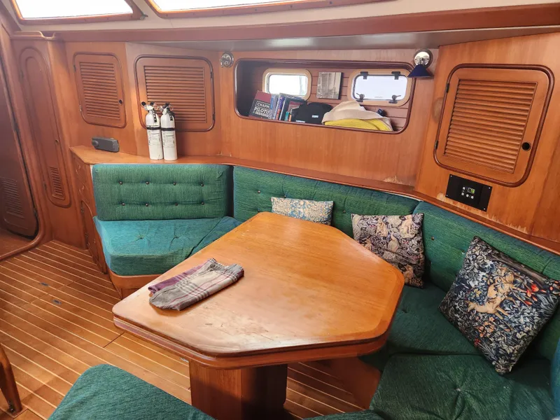 Slide: The Image of Cozy interior of 1989 Taswell 43 sailboat with green seating and wooden table. - 25