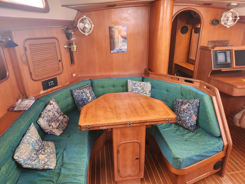 Slide: The Image of Interior of 1989 Taswell 43 yacht with wooden table and green cushioned seating. - 26