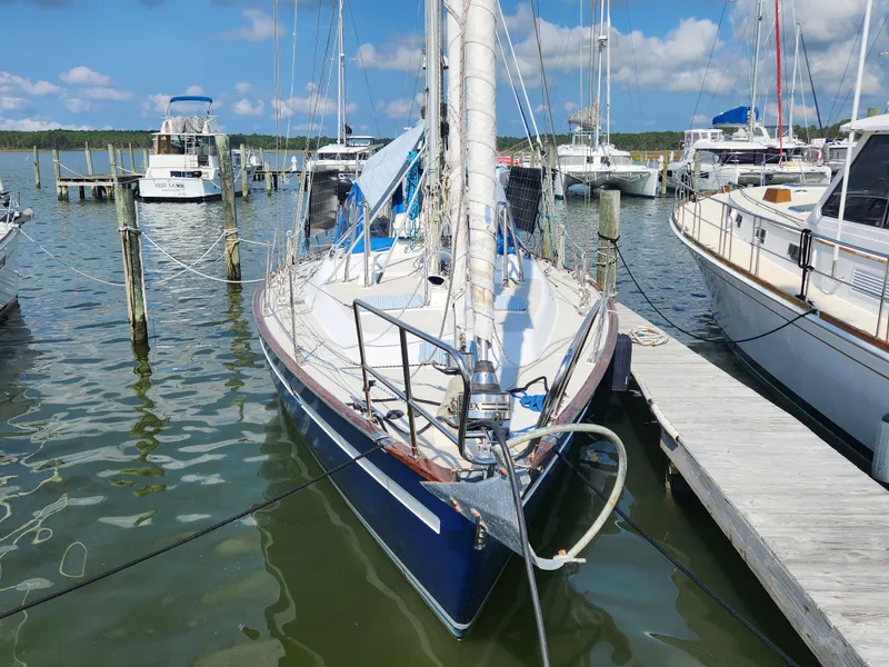 Slide: The Image of 1989 Taswell 43 sailboat docked at marina, surrounded by other boats under a clear blue sky. - 3
