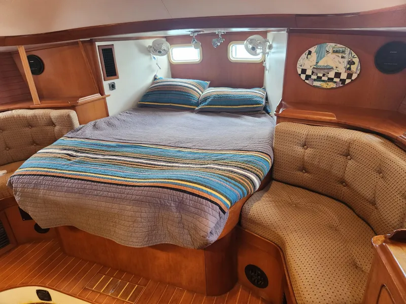 Slide: The Image of Cozy cabin interior of 1989 Taswell 43 yacht with striped bedding and cushioned seating. - 31