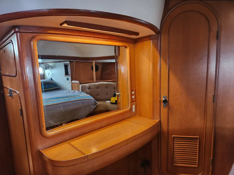 Slide: The Image of Interior of 1989 Taswell 43 yacht with wooden cabinetry and mirror reflecting cozy bedroom. - 33