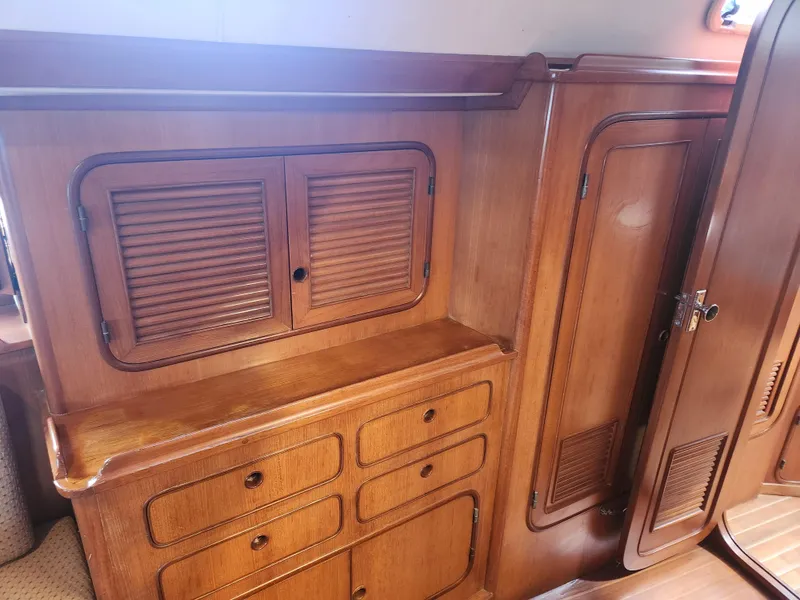 Slide: The Image of Wooden interior cabinetry of a 1989 Taswell 43 yacht, featuring drawers and louvered doors. - 34