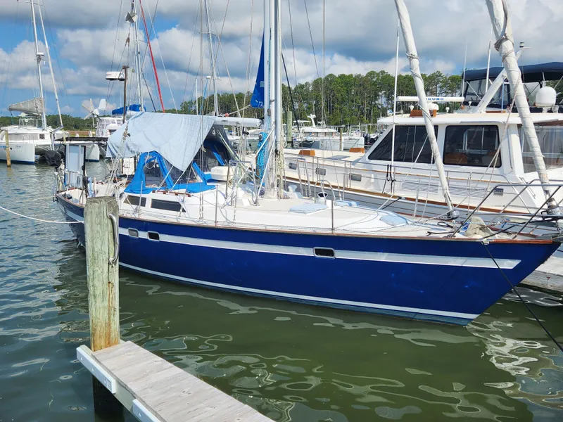 Slide: The Image of 1989 Taswell 43 sailboat docked in marina, featuring a blue hull and white deck. - 4