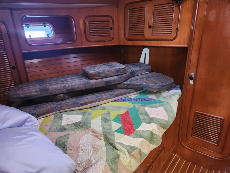 Slide: The Image of Cozy cabin interior of 1989 Taswell 43 sailboat with colorful quilt and wooden paneling. - 40
