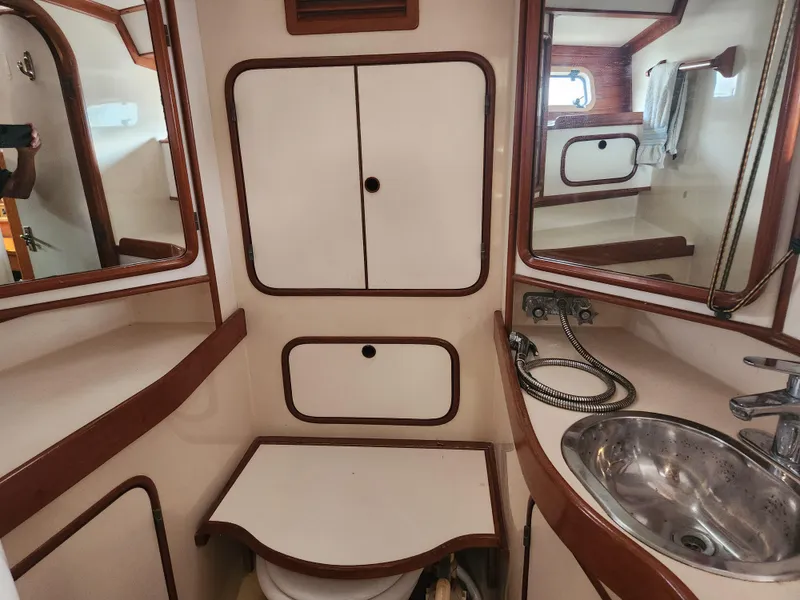 Slide: The Image of Interior of 1989 Taswell 43 yacht bathroom with sink, mirrors, and storage cabinets. - 43