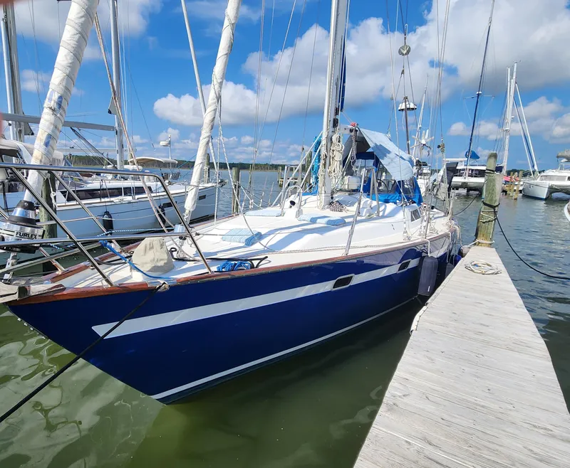 Slide: The Image of 1989 Taswell 43 sailboat docked at marina under blue sky. - 46