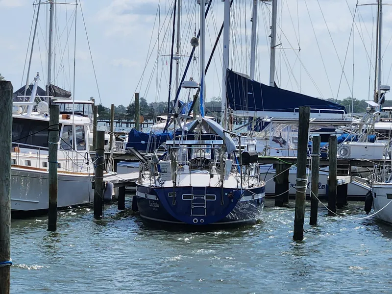 Slide: The Image of Sailboats docked at a marina, featuring a 1989 Taswell 43 yacht. - 5