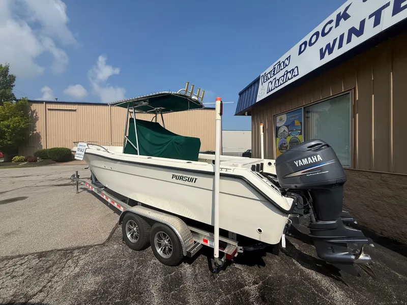 The Image of 2002 Pursuit 2470 CC boat on trailer, parked outside Venetian Marina, with Yamaha outboard motor. - 1