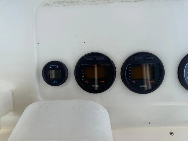 Slide: The Image of Dashboard gauges on a 2002 Pursuit 2470 CC boat, featuring Yamaha displays. - 12