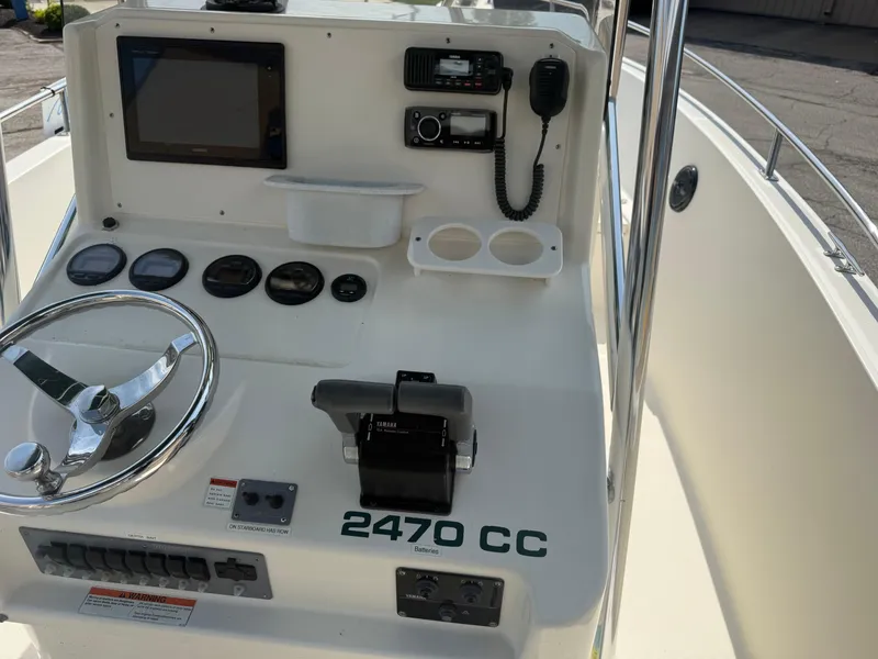 Slide: The Image of Center console of a 2002 Pursuit 2470 CC boat with steering wheel and controls. - 13