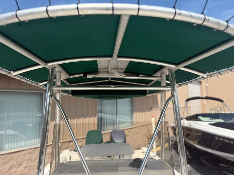 Slide: The Image of 2002 Pursuit 2470 CC boat with green T-top canopy and stainless steel frame. - 14