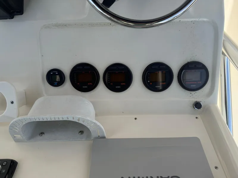 Slide: The Image of Dashboard of a 2002 Pursuit 2470 CC boat with gauges and steering wheel. - 15