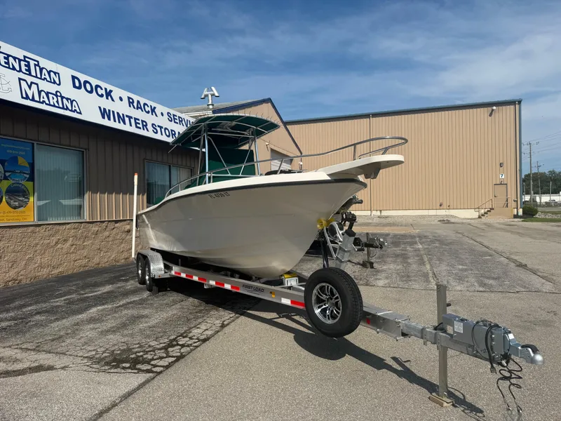 Slide: The Image of 2002 Pursuit 2470 CC boat on trailer outside marina building. - 22