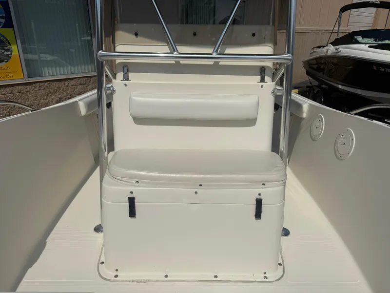 Slide: The Image of 2002 Pursuit 2470 CC boat interior with white seating and storage. - 5