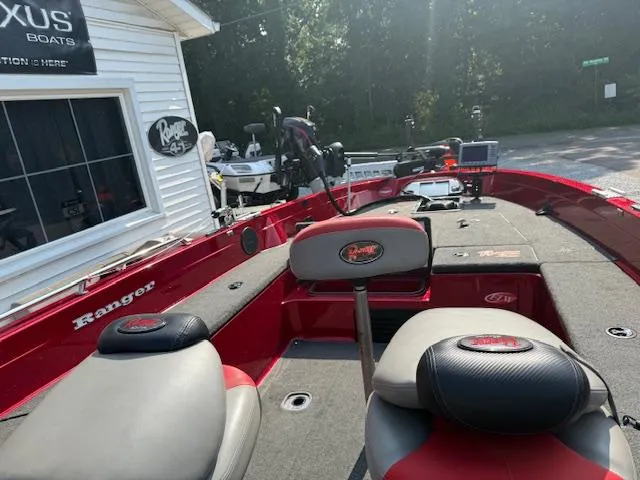 Slide: The Image of 2011 Ranger 618 T boat with red and gray interior, parked outside a dealership. - 6