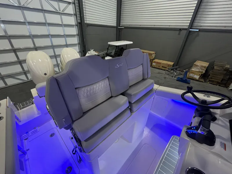 Slide: The Image of 2026 Scout 260 LXF boat interior with illuminated seating and dual engines in a garage. - 13