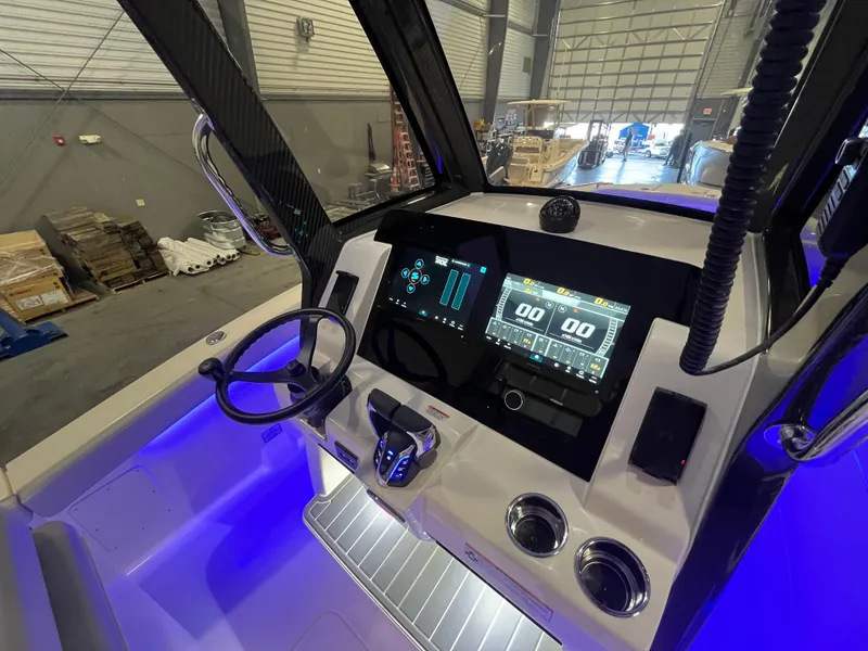 Slide: The Image of 2026 Scout 260 LXF boat dashboard with modern controls and illuminated blue lighting. - 16