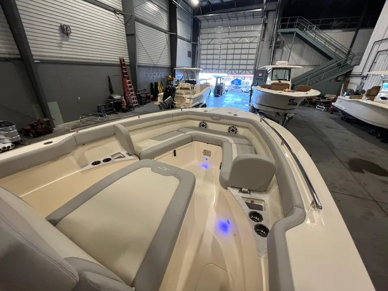 Slide: The Image of 2026 Scout 260 LXF boat interior in a showroom, featuring modern seating and ambient lighting. - 17