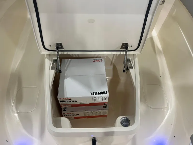 Slide: The Image of Open storage compartment on 2026 Scout 260 LXF boat with Yamaha propeller box inside. - 19