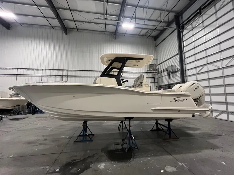 Slide: The Image of 2026 Scout 260 LXF boat with Yamaha engine in a warehouse setting. - 2