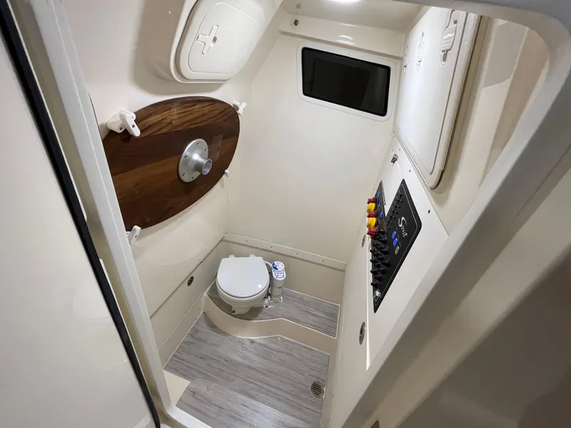Slide: The Image of 2026 Scout 260 LXF boat interior bathroom with toilet and control panel. - 22