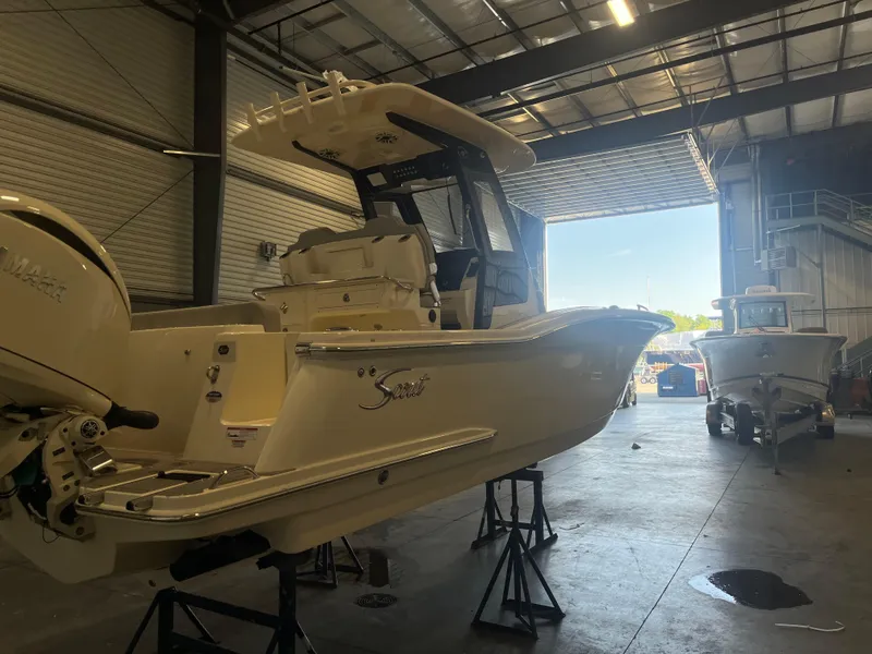 Slide: The Image of 2026 Scout 260 LXF boat in a warehouse, elevated on stands. - 3