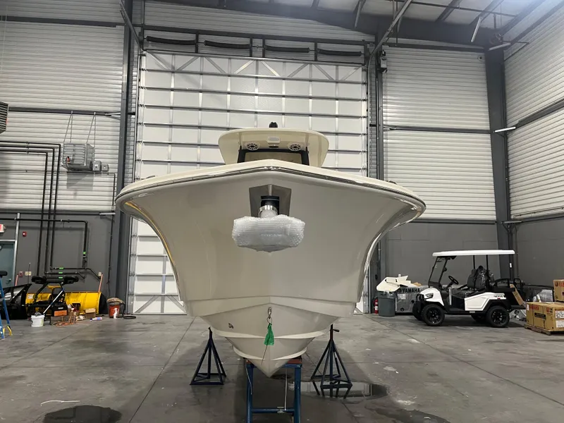 Slide: The Image of 2026 Scout 260 LXF boat in a warehouse, front view, with golf cart nearby. - 4