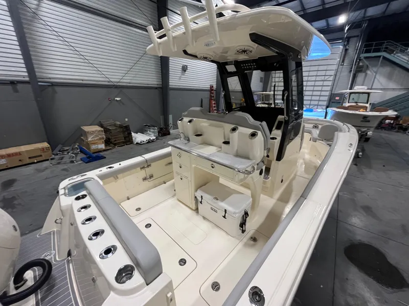 Slide: The Image of 2026 Scout 260 LXF boat interior in a warehouse, showcasing seating and storage features. - 8