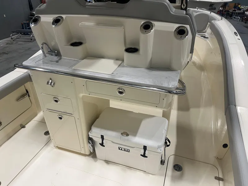 Slide: The Image of 2026 Scout 260 LXF boat interior with storage, sink, and Yeti cooler. - 9