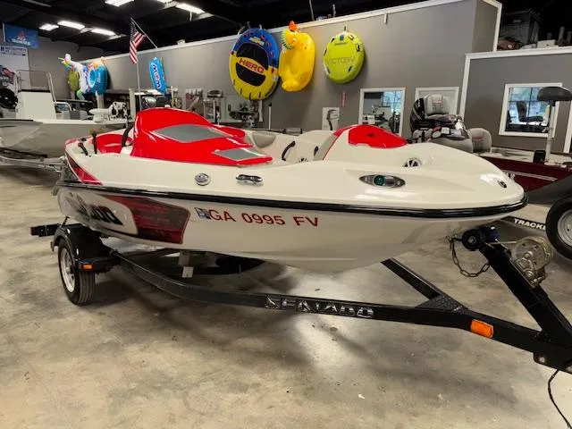 Slide: The Image of 2008 Sea-Doo 150 Speedster boat with red accents on display in a showroom. - 1
