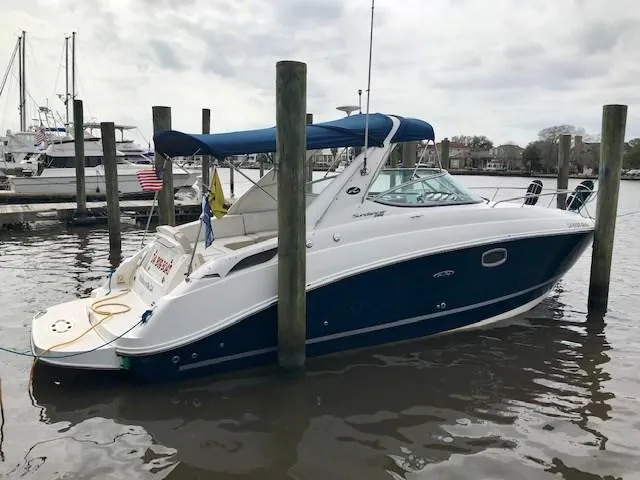 Slide: The Image of 2012 Sea Ray 280 Sundancer boat docked in a marina with blue canopy. - 1