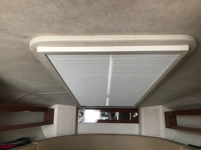 Slide: The Image of Interior cabin view of a 2012 Sea Ray 280 Sundancer boat, featuring a ceiling hatch. - 26