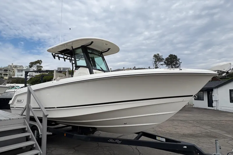 Slide: The Image of 2026 Boston Whaler 250 Outrage boat on trailer, dockside view. - 3