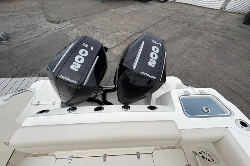 Slide: The Image of 2026 Boston Whaler 250 Outrage with twin Mercury 200 V6 engines, docked on pavement. - 4