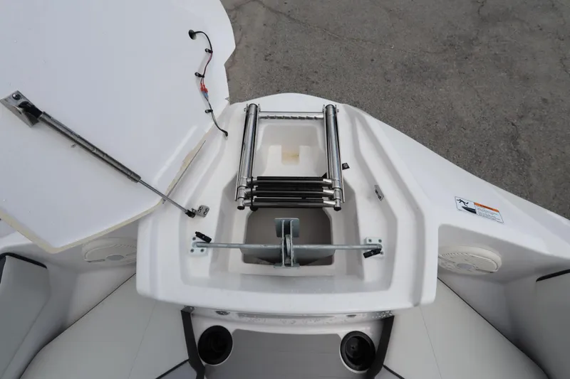 Slide: The Image of 2024 Yamaha Boats SX220 bow storage with ladder and anchor compartment. - 13
