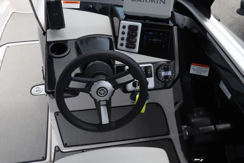 Slide: The Image of 2024 Yamaha Boats SX220 dashboard with steering wheel and Garmin navigation system. - 16
